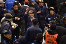 Kazuhiro mengacungkan tangan untuk menawar ikan tuna//AFP/Getty Images