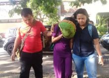 Vanessa Angel menutup wajah saat sampai di Mapolda Jawa TImur, beberapa saat setelah diamankan dari salah satu hotel di Surabaya. Foto: int 