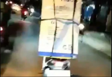 Seorang driver ojol ibu-ibu yang tertangkap kamera tengah membawa mesin cuci pesanan seseorang. Foto: int 