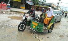 Pengendara becak menghindari jalan rusak Suka Karya (foto/riki)