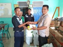 Ketua Koperasi Tinera Jaya Suhailis (2 kiri), didampingi Ketua Badan Pengawas Koperasi Ns. Alek Sandra. S.Kep (kiri) menyerahkan bantuan secara simbolis kepada kadus/lin  