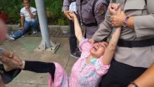 Prihatini yang tampak histeris saat diamankan petugas di depan Gedung MK Jakarta. Foto: int 