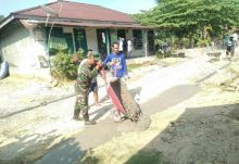 Babinsa Koramil 09/Langgam bersama warga membuat parit dan kanan jalan