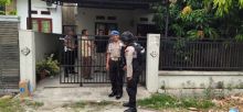 Pihak kepolisian saat berjaga di rumah penjahat kakap Satriandi di Pekanbaru