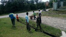 Babinsa Koramil 12/XIII Koto Kampar Peltu Marjian, melakukan gotong royong bersama warga membersihkan parit di sepanjang jalan Desa Ranah Sungkai