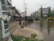 Sejumlah pengendara sepeda motor dibuat kewalahan saat harus melewati badan jalan yang digenangi air pasang laut (foto/bie)