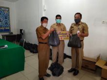 Gugus Tugas Pemkab Kuansing yang di pimpin oleh Asisten III Setda Kuansing, DR. Agus Mandar, S.Sos. M.Si bersama Asisten I Setda Kuansing, Muhjelan Arwan, SH. MH menyerahkan bantuan Sembako (foto/Zar)