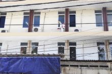 Petugas sedang menyemprotkan disinfektan di asrama mahasiswa STT Bethel setelah ditemukan adanya mahasiswa yang terinfeksi corona. Foto/SINDOnews