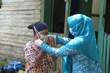 Masdiana (60) warga Kelurahan Sungai Mempura tidak menyangka sekaligus terharu saat menerima bantuan sembako dan masker yang langsung diantar Ketua PKK Kabupaten Siak Rasidah Alfedri (foto/ist)