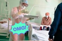 Perawat merawat pasien dengan menggunakan APD transparan