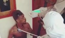 Tersangka MN diamankan petugas yang mengenakan APD lengkap. Foto:int