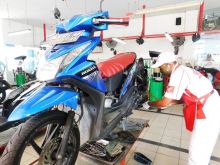 Mekanik service motor Honda milik konsumen menggunakan masker dan sarung tangan