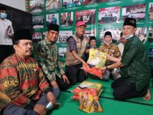 Bendahara GNP Covid, Alexander Pranoto disaksikan Ketua Umum GNP Covid, T.Rusli Ahmad menyerahkan bantuan kepada Anton