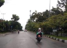 Tampak seorang murid SD tengah di bonceng orang tuanya menuju sekolah