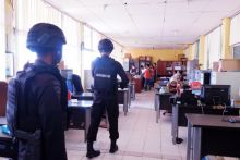 Personil Brimob Polda Riau terlihat mendampingi Tim Pidsus Kejati Riau Menggledah kantor Disdik Riau. (Foto. Amri)