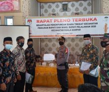 Kapolsek Kuala Kampar Iptu Hanova Siagian menerika dokumen hasil Rapat Pleno Rekapitulasi Hasil Penghitungan Perolehan Suara Pilkada Pelalawan Tingkat Kecamatan di Mess Penghulu Jogel, Kelurahan Teluk Dalam, Sabtu (12/12/2020). Foto: Istimewa.