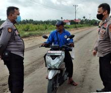 Personel Polsubsektor Pelalawan saat mendapati seorang pengendara motor tak mengenakan masker, Minggu (13/12/2020). Foto: Istimewa. 