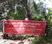 Personel Polsek Bandar Sei Kijang dan warga membentangkan spanduk tentang larangan karhutla, Minggu (13/12/2020). Foto: Istimewa. 