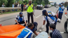 Petugas mengamankan jasad pria tak dikenal, yang tewas saat menyeberangi jalan tol dengan berjalan kaki. Foto: int/viva