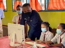 CEO PTPN V, Jatmiko K Santosa, menjajal perangkat komputer dan jaringan internet di salah satu sekolah terpencil di Kabupaten Rokan Hulu, Riau. PTPN V membagikan 25 unit PC berikut akses internet selama setahun penuh kepada 25 sekolah di wilayah terpencil di Riau (foto/ist) 