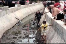 Warga masuk selokan untuk mendapatkan bingkisan dari Presiden Joko Widodo