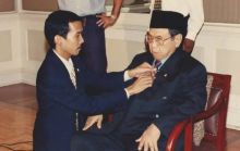 Priyo Sambadha merapikan pakaian Presiden Gus Dur sebelum wawancara dengan media asing. Sumber: alif.id