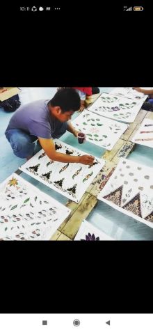 Muharimin (39) memainkan lilin malam diatas bentangan kain