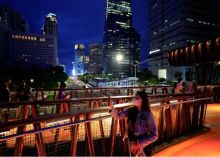 Foto : Orang-orang yang memakai masker pelindung menikmati jembatan penyeberangan saat senja di tengah pandemi penyakit virus corona (Covid-19) di Jakarta, Indonesia, pada 15 Maret 2022. Reuters