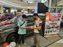 Sales Honda sedang memberikan penjelasan program kejutan Honda kepada pengunjung