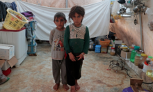 Foto : Kembar Jumana dan Farhan al-Alyawi berpose untuk foto di tenda di Kamp Atmeh dekat perbatasan Turki [File: Khalil Ashawi/Reuters]