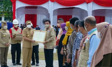 Gubernur Riau, Syamsuar menyerahkan Penghargaan K3 kepada Presiden Direktur RAPP, Sihol Aritonang saat Apel Peringatan Bulan K3 Nasional di PT Riau Andalan Pulp and Paper (APRIL Group), Selasa (15/02/2022), Pangkalan Kerinci, Kabupaten Pelalawan.