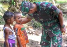 Dandim 0303/Bengkalis Letkol Inf Endik Y H saat merangkul dua bocah di sasaran TMMD