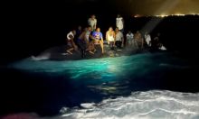 Foto: Korban selamat dari kapal yang terbalik hinggap di kapal terbalik di lepas pantai pulau New Providence di Bahama