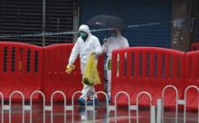 Foto : Personil karantina dengan alat pelindung lengkap mengumpulkan sampel di Pasar Makanan Laut Huanan di Wuhan pada Januari 2020. Foto: Simon Song