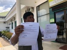 Memperlihatkan Surat yang disebut bukti penitipan uang di Bank