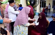 Bupati Bengkalis saat menyerahkan bantuan kepada masyarakat Desa Sepahat