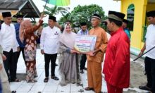 Bupati Kasmarni saat menyerahkan bantuan kepada anak yatim dan kaum dhuafa