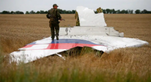 Gambar menunjukkan separatis bersenjata pro-Rusia di atas puing-puing Malaysia Airlines MH17 setelah jatuh di dekat pemukiman Grabovo di wilayah Donetsk, Ukraina, pada 2014 /Reuters