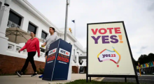 Para pemilih berjalan melewati tanda Pilih 'Ya' dan Pilih 'Tidak' di Gedung Parlemen Australia Lama, selama referendum The Voice di Canberra, Australia, 14 Oktober 2023 /Reuters