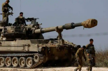 Tentara Israel dari unit artileri mengendarai kendaraan militer di dekat sisi perbatasan Israel antara Israel dan Jalur Gaza /Reuters