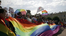 Orang-orang mengibarkan bendera dan mengangkat slogan-slogan sambil berdemonstrasi untuk hak-hak LGBTQ /Reuters
