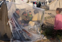 Warga Palestina yang mengungsi, yang meninggalkan rumah mereka karena serangan Israel, duduk di tempat penampungan sementara mereka di sebuah kamp tenda ketika konflik antara Israel dan Hamas berlanjut, di Rafah, di Jalur Gaza selatan 12 Desember 2023 /Reuters