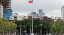 Seseorang berjalan di samping bendera Taiwan yang berkibar di luar Balai Peringatan Sun Yat-Sen di Taipei /Reuters