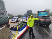 Petugas Satlantas Polresta Pekanbaru terlihat tengah mengatur lalulintas saat akan mengevakuasi mobil bus dan truk yang memakan badan jalan.