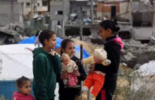 Dalam foto dari 28 Januari 2024 ini, anak-anak Palestina bermain di depan puing-puing di sebuah kamp darurat yang menampung pengungsi Palestina di Rafah /AFP
