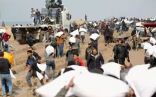 Warga Palestina membawa kantong tepung yang mereka ambil dari truk bantuan di dekat pos pemeriksaan Israel /Reuters