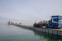 Gambar sebuah truk yang membawa bantuan kemanusiaan melintasi Dermaga Trident, dermaga sementara untuk mengirimkan bantuan, di Jalur Gaza, di tengah konflik yang sedang berlangsung antara Israel dan kelompok Islam Palestina Hamas, dekat pantai Gaza, 19 Mei 2024 /Reuters