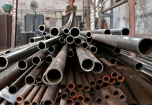 Seorang pekerja menumpuk pipa baja di kota Ahmedabad, India bagian barat, 4 November 2014 /Reuters