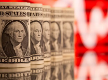 Uang kertas satu dolar AS terlihat di depan grafik saham yang ditampilkan dalam ilustrasi ini /Reuters