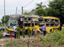 Petugas keamanan bersama pihak berwenang berdiri di samping bus yang mengalami kecelakaan di provinsi Ha Tinh, Vietnam Tengah /AFP